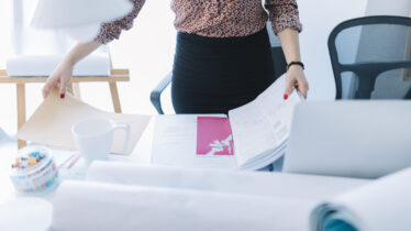 close-up-businesswoman-holding-opened-file-desk